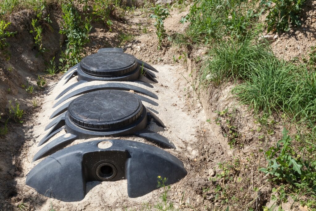 Image of a septic tank for a domestic house installed in a sand bed ready for connection to the gravel filter bed for disposal and treatment of household effluent and sewage.